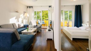 A modern living room with a sofa, a coffee table, and a view of a balcony.