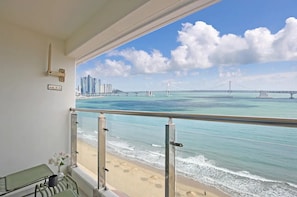 Un balcone con vista sulla spiaggia e su un ponte.