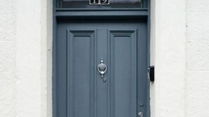 Una puerta azul oscuro con una placa que indica el número 19.