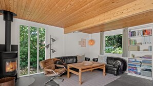 Un salon moderne avec une cheminée, des canapés en cuir, une table basse et une bibliothèque.