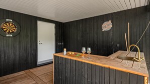 Une cuisine avec un plan de travail en bois, un jeu de fléchettes et un panneau sur lequel on peut lire : « Couleurs et rêves ».