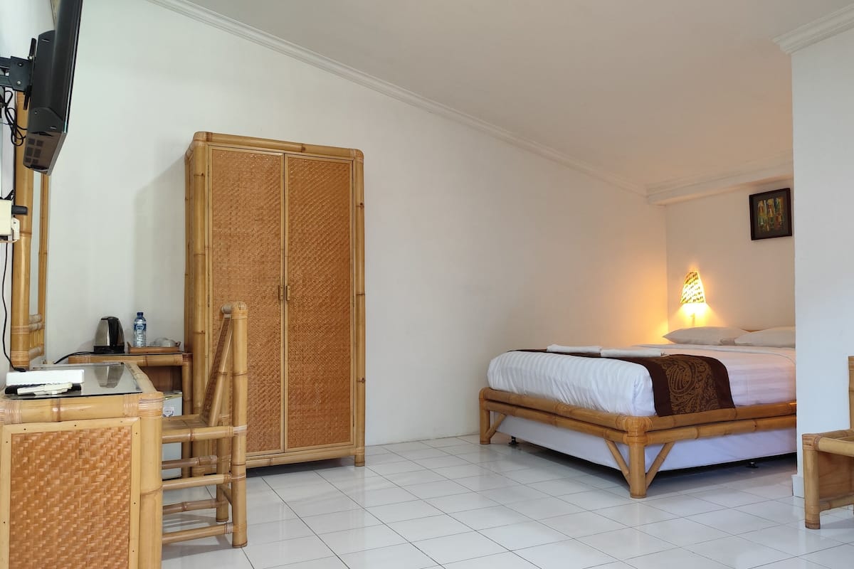 A room with a bed, a desk, a chair, and a wardrobe.