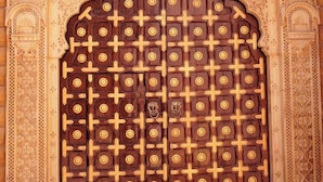A large wooden door with intricate carvings and a decorative archway. - Hinduja Haveli  (Jodhpur)