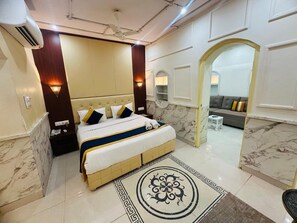 A modern hotel room with a large bed, marble flooring, and a decorative rug. - Hinduja Haveli (Jodhpur)