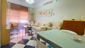 A hotel room with a checkered floor, a sofa, a dining table, and a bed. - Comeback Torrenueva Costa (Torrenueva Costa)