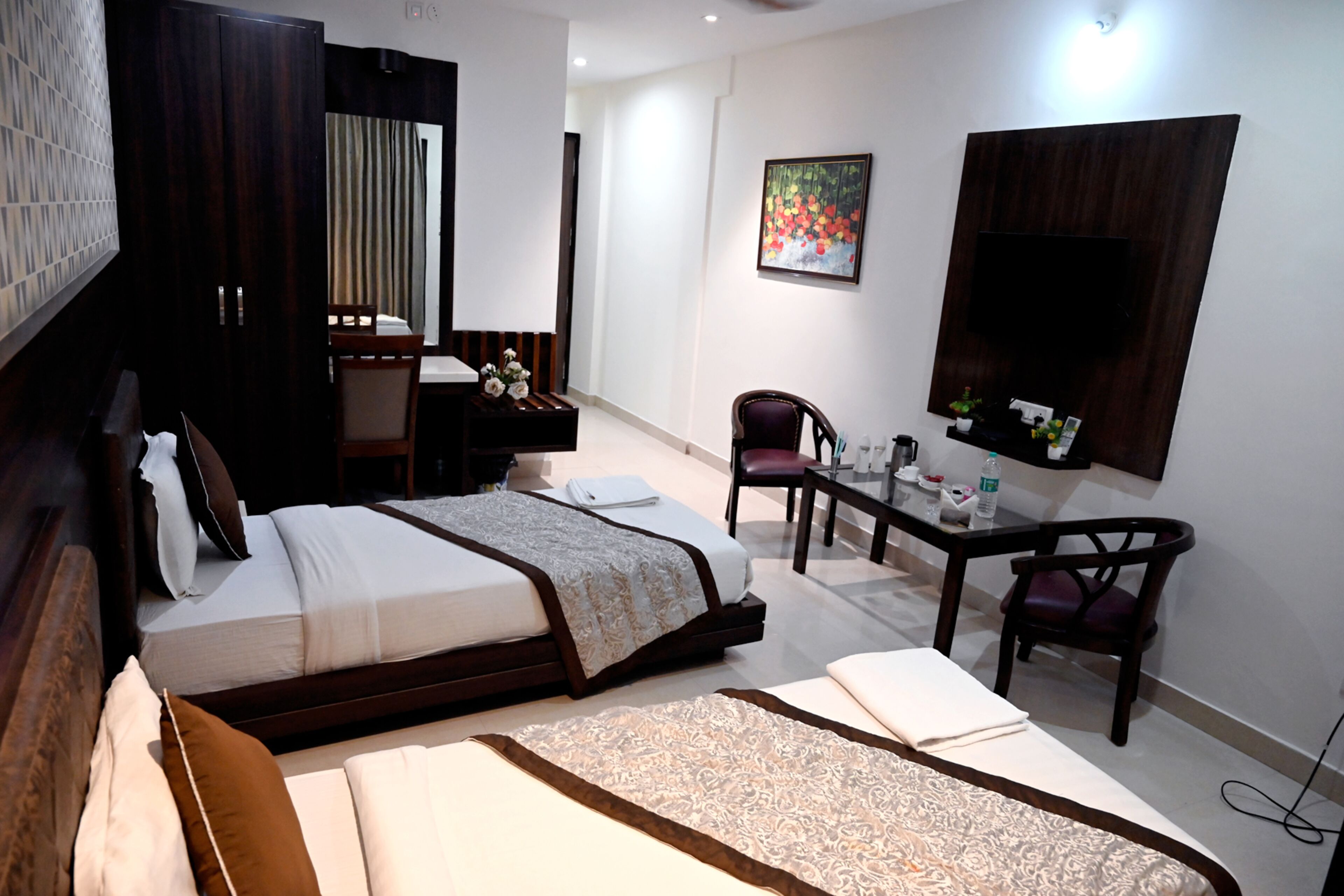 Une chambre d’hôtel avec un lit, un bureau, une chaise et un téléviseur.