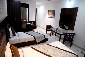 A hotel room with a bed, a desk, a chair, and a TV.