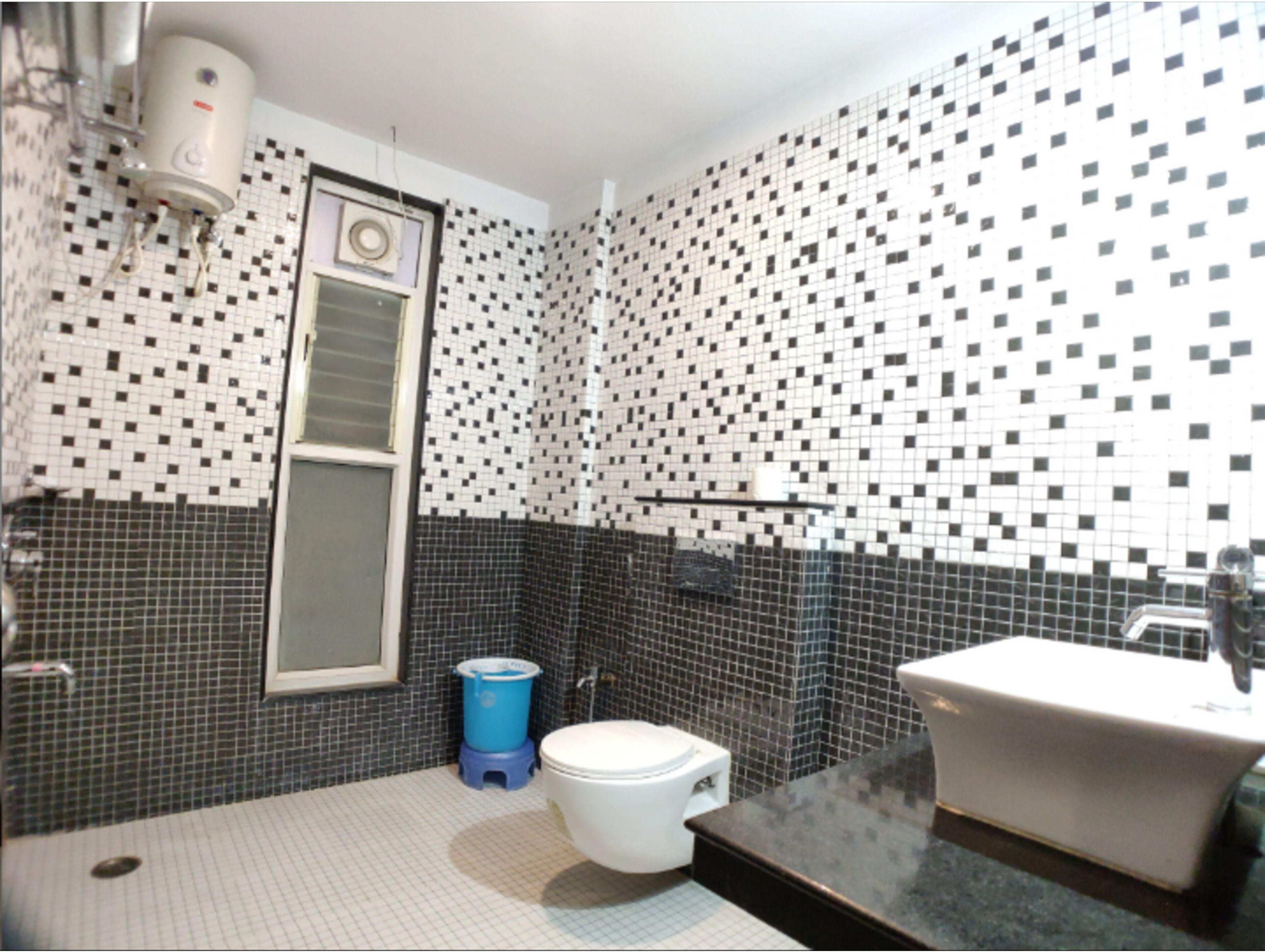 Ein Badezimmer mit Toilette, Waschbecken und einer blauen Mülltonne.