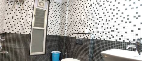 Ein Badezimmer mit Toilette, Waschbecken und einer blauen Mülltonne.