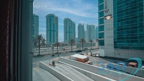 A view of a cityscape with tall buildings, a clear sky, and a road with vehicles. - Stylish Studio in Dubai Marina Close to the Beach, Mall and Metro (Dubai)