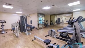 A gym with various exercise equipment, including treadmills, stationary bikes, and weight machines. - Stylish Studio in Dubai Marina Close to the Beach, Mall and Metro (Dubai)