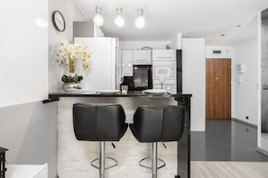 Mikrobølgeovn, oppvaskmaskin, høy barnestol og kjøkkenutstyr