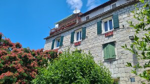 A stone building with green shutters and a sign for 'Ninfa Rooms'. - Nirvana Garden Rooms (Split)