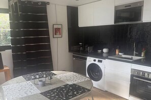 A compact kitchen with a washing machine, a microwave, and a sink.