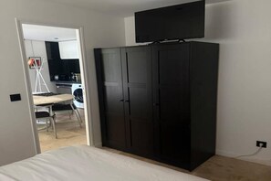 Ein Schlafzimmer mit einem Bett, einem Kleiderschrank und einem Fernseher.