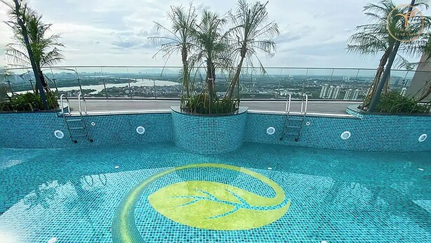 A swimming pool with a blue mosaic floor and a green circular design in the center.