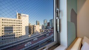 A view from a hotel room window overlooking a cityscape with a highway and buildings. -  HOP INN Tokyo Iidabashi (Tokyo)