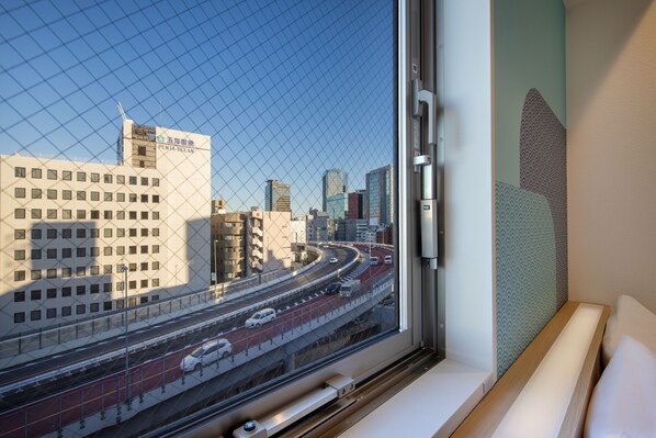 A view from a hotel room window overlooking a cityscape with a highway and buildings. - HOP INN Tokyo Iidabashi (Tokyo)