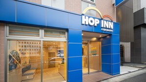 A hotel entrance with a blue facade, large glass windows, and a sign reading "HOP INN". -  HOP INN Tokyo Iidabashi (Tokyo)
