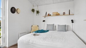 A modern bedroom with a large bed, white walls, and a ceiling light. - "Ovine" - 300m from the sea by Interhome (Juelsminde)