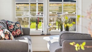 A room with a large window, two grey sofas, and a wicker chair. - "Ovine" - 300m from the sea by Interhome (Juelsminde)