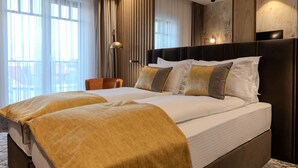A hotel room with a large bed, a chair, a lamp, and a view of the outdoors through the window. - Hotel Branco Timisoara (Timisoara)