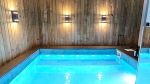 A wooden-paneled room with a blue pool. - Hotel Branco Timisoara (Timisoara)