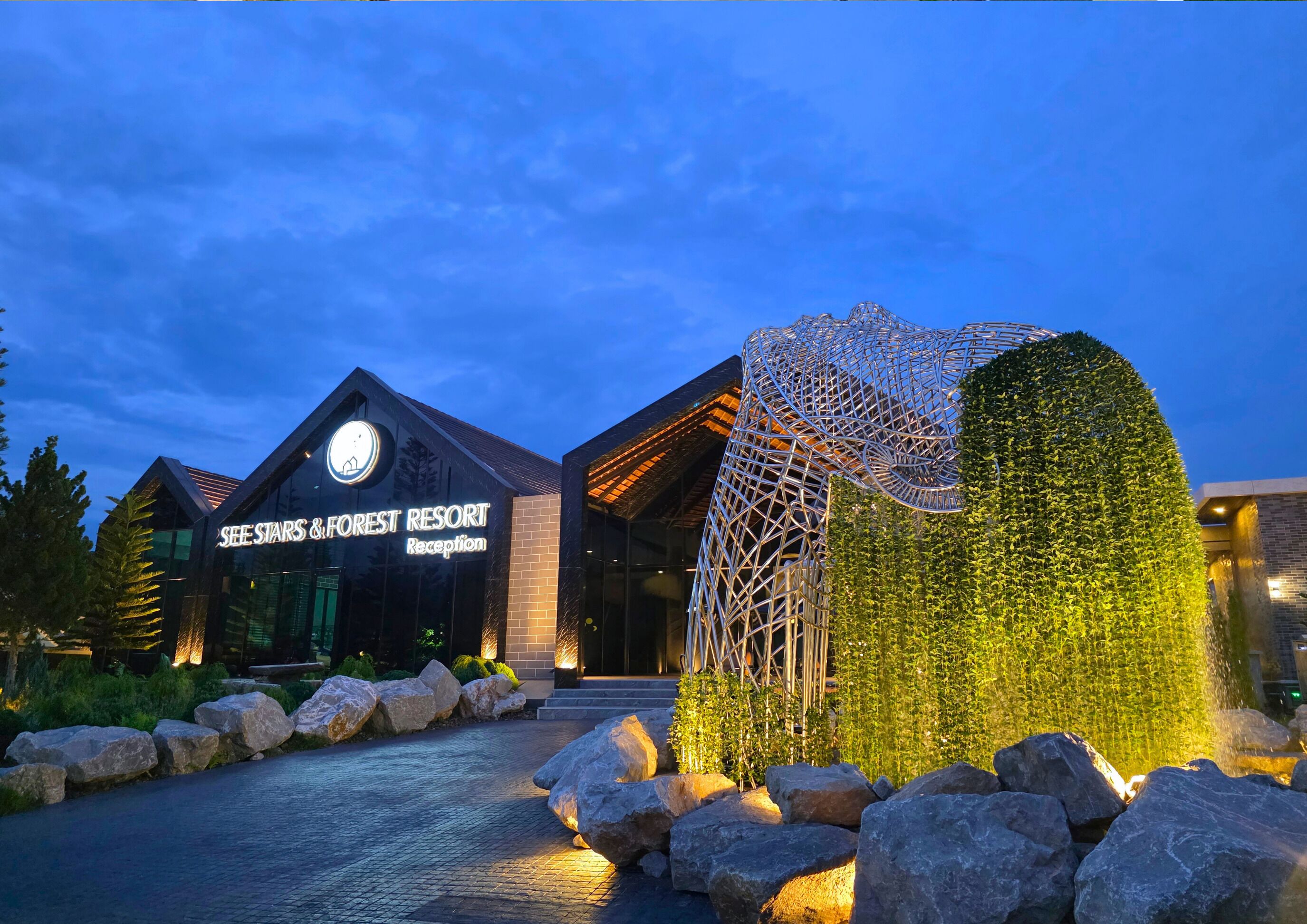 Ein modernes Gebäude mit einer Rezeption, auf der steht: "See Stars & Forest Resort Reception".