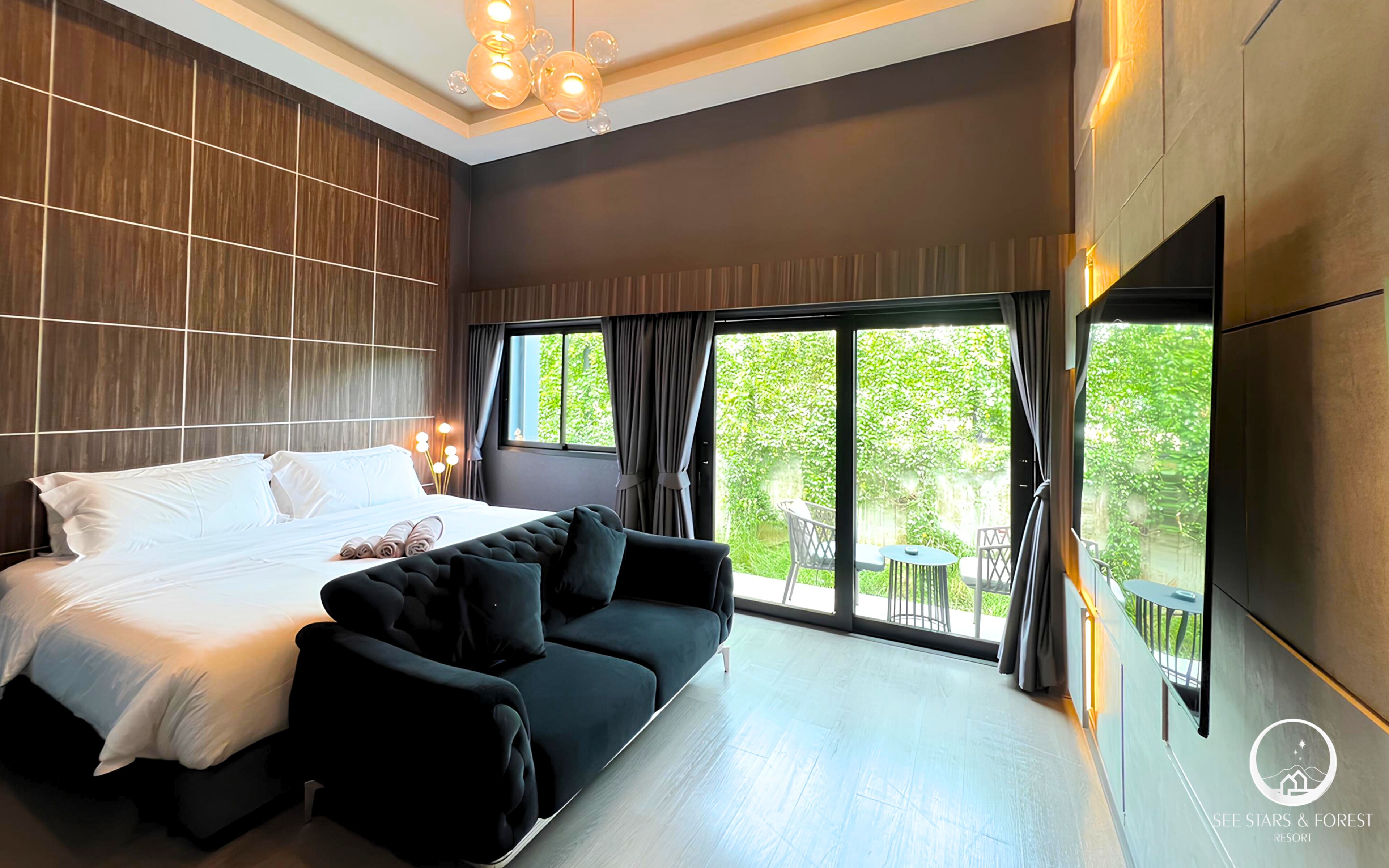 Un dormitorio moderno con una cama grande, un sofá y una televisión en la pared.
