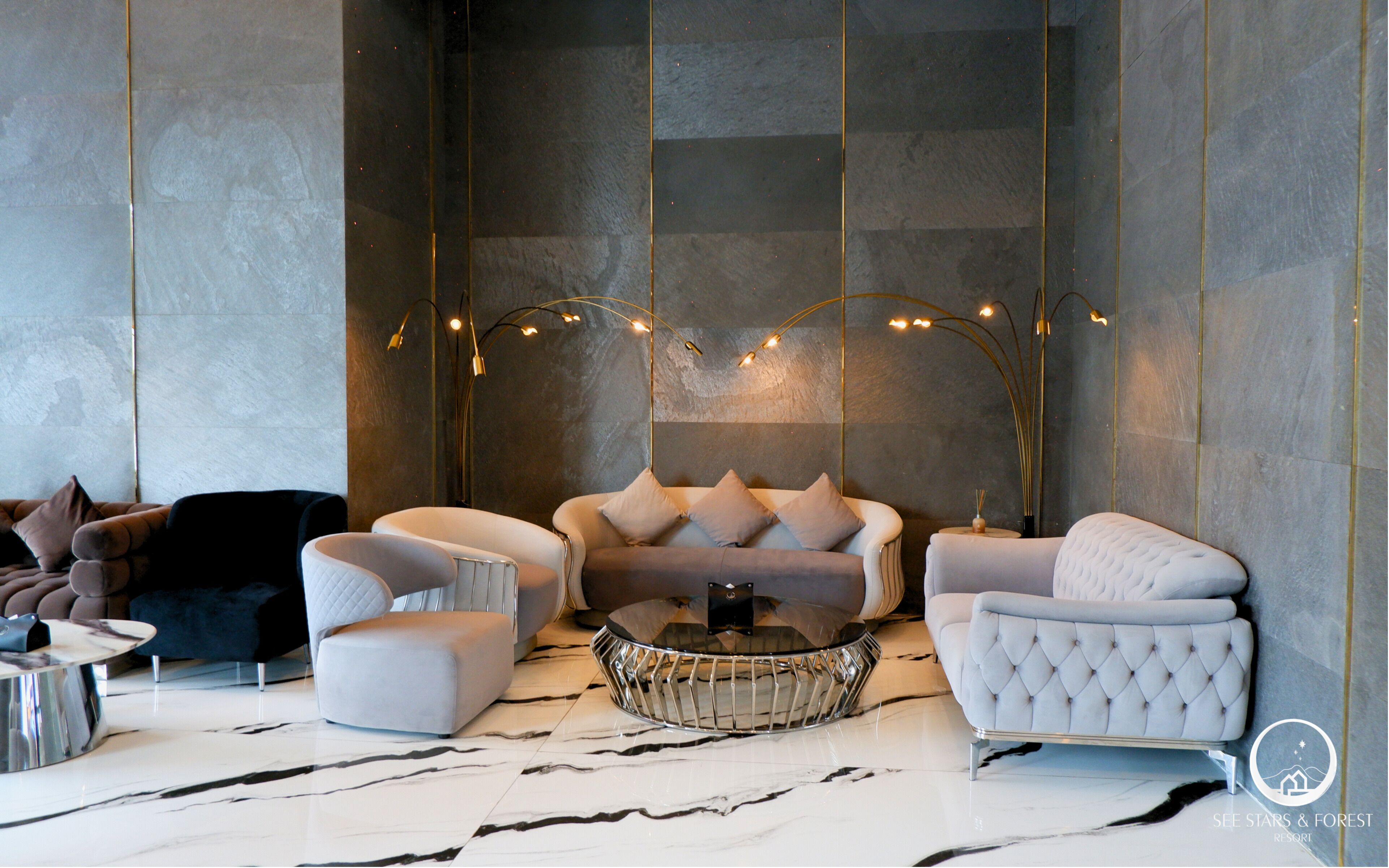 A modern living room with a sofa set, a coffee table, and a decorative light fixture.