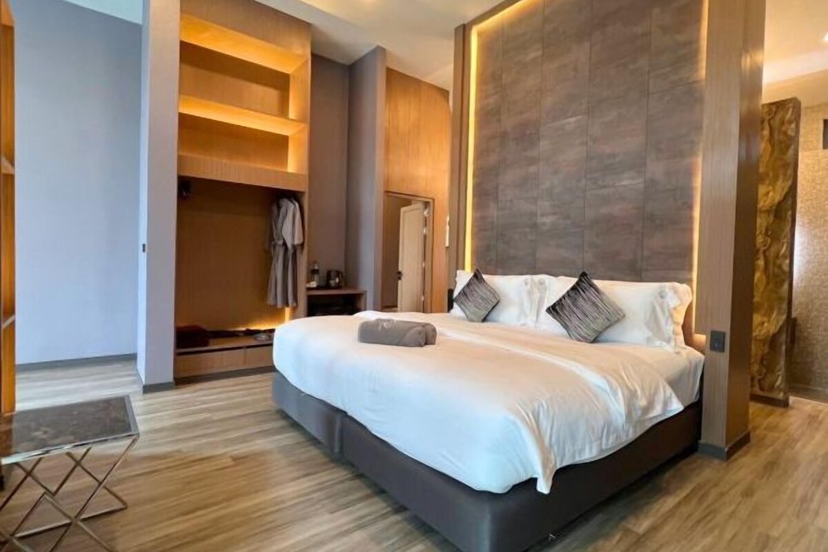 Una habitación de hotel moderna con una cama grande, estanterías integradas y un diseño minimalista.
