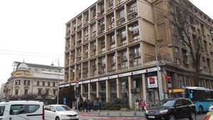 Ein mehrstöckiges Gebäude mit einem zentralen Eingang, Balkonen und einem Schild, das ein BRD Hotel anzeigt.