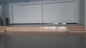 Una habitació amb un espai ampli i buit al centre, possiblement per a una piscina o una taula gran.