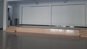 Habitació amb un televisor de pantalla plana gran fixat a la paret, una cadira incorporada amb un disseny estampat i una escala que condueix a un nivell superior.