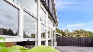 A modern building with large windows and a wooden deck. - "Sylvi" - 750m from the sea by Interhome (Hals)