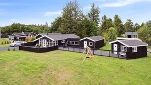 A row of black cabins with white trim, surrounded by a grassy area and trees. - "Sylvi" - 750m from the sea by Interhome (Hals)