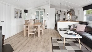 A spacious living area with a dining table, chairs, a sofa, and a kitchen in the background. - "Sylvi" - 750m from the sea by Interhome (Hals)