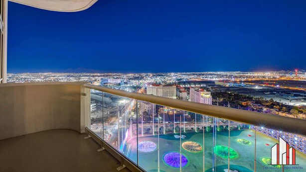 A balcony with a city view at night, featuring illuminated circular patterns on the ground. - MGM Signature-28-820 1Br 2Ba F1 Pits View Balcony (Las Vegas)