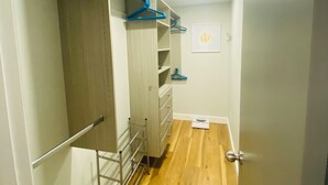 A narrow hallway with wooden flooring, a metal rack, and a closet with hanging clothes. - 7min to Uptown - 2 Ensuites Suites w/Veranda (Charlotte)