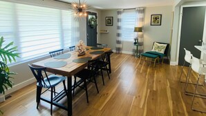 A dining area with a wooden table, black chairs, and a modern chandelier. - 7min to Uptown - 2 Ensuites Suites w/Veranda (Charlotte)