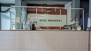 A reception area with a sign reading "HOTEL NUSANTARA". - Hotel O Nusantara (Banyuwangi)