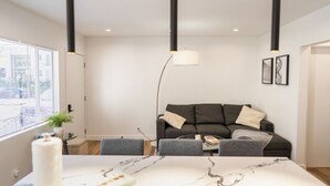 A modern living room with a dark grey sofa, a white marble coffee table, and a floor lamp.