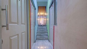 A hallway with a marble staircase leading to a landing. - OYO Life 92877 Hotel Rainbow 7296 (Semarang)