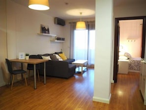 Een gezellige, compacte ruimte met een eethoek, bank en een kleine kitchenette.