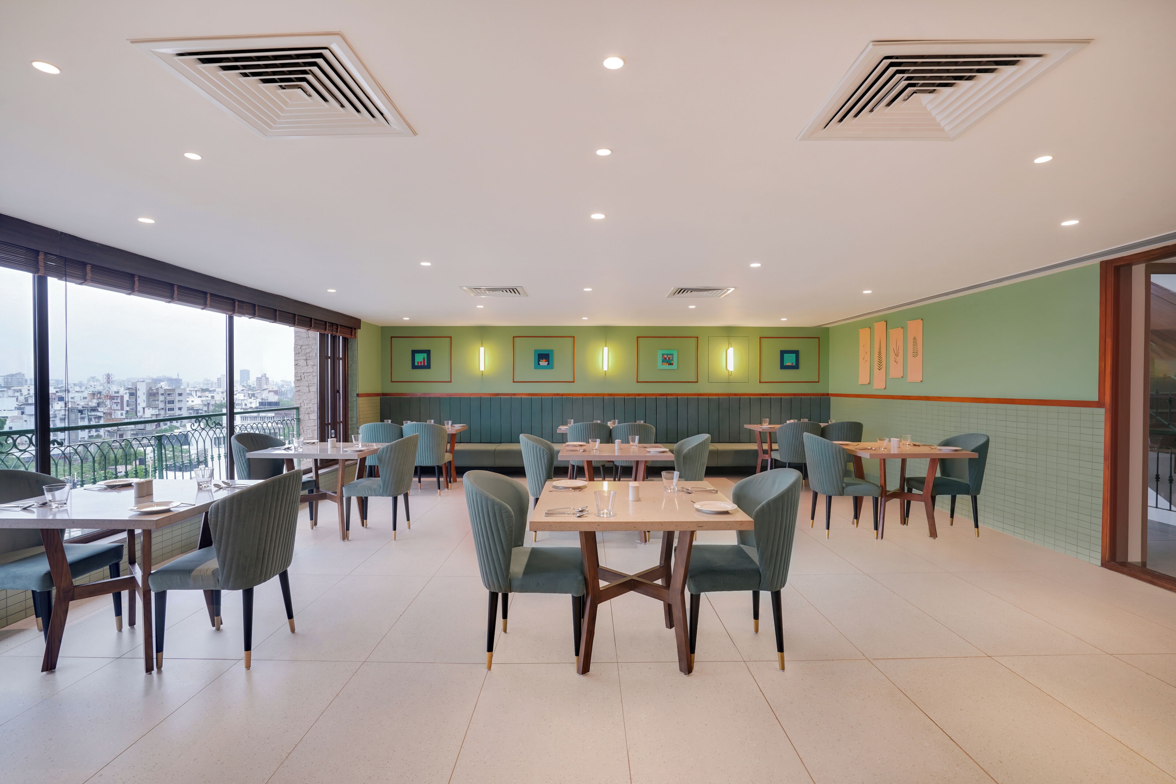 Uma sala de jantar moderna com mesas, cadeiras, janelas amplas e vista para a cidade.