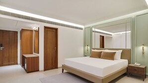 Un dormitorio moderno con una cama grande, un armario de madera y un espejo.