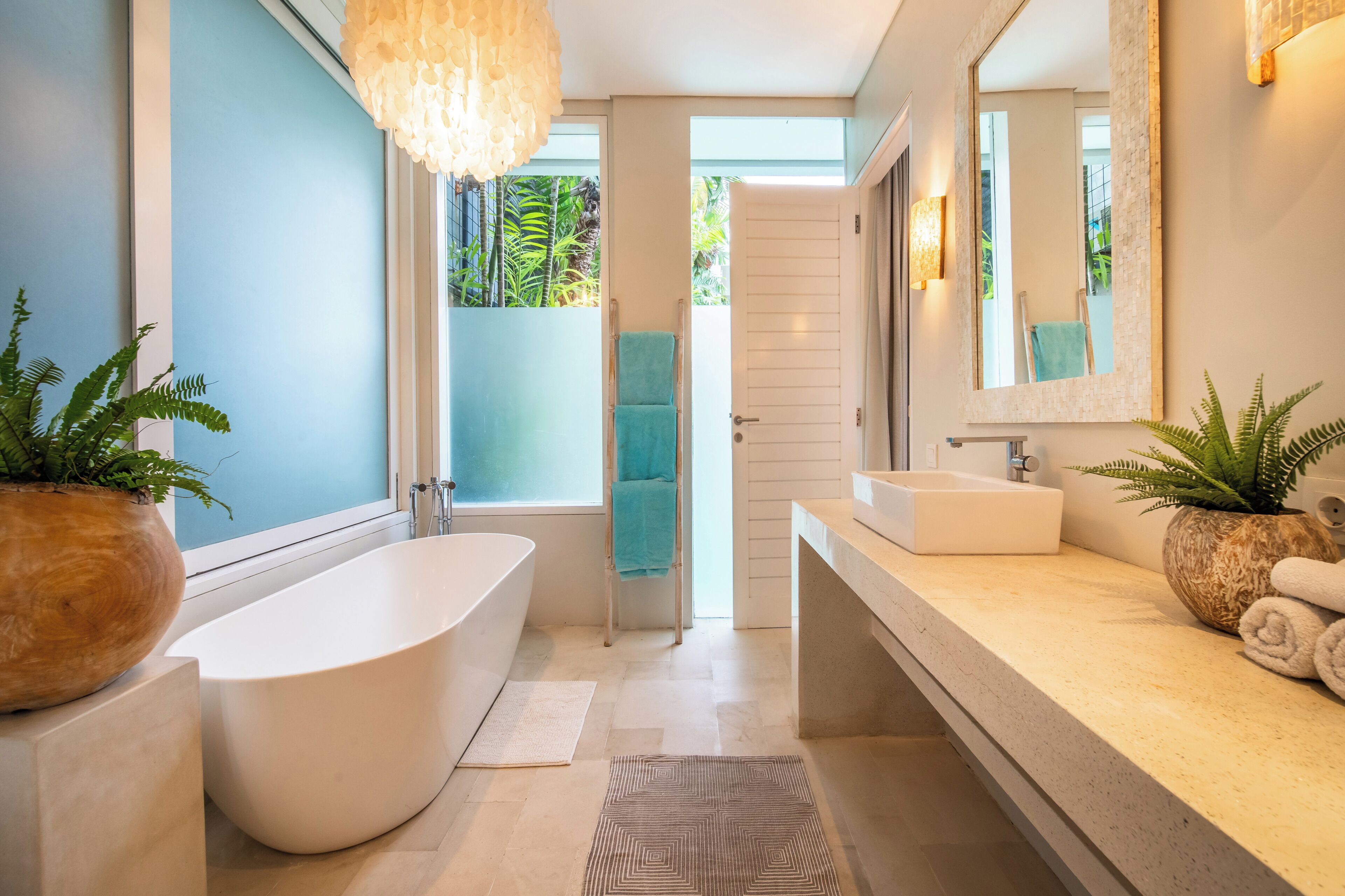 Une salle de bain moderne avec une baignoire sur pieds, un grand miroir et deux lavabos.