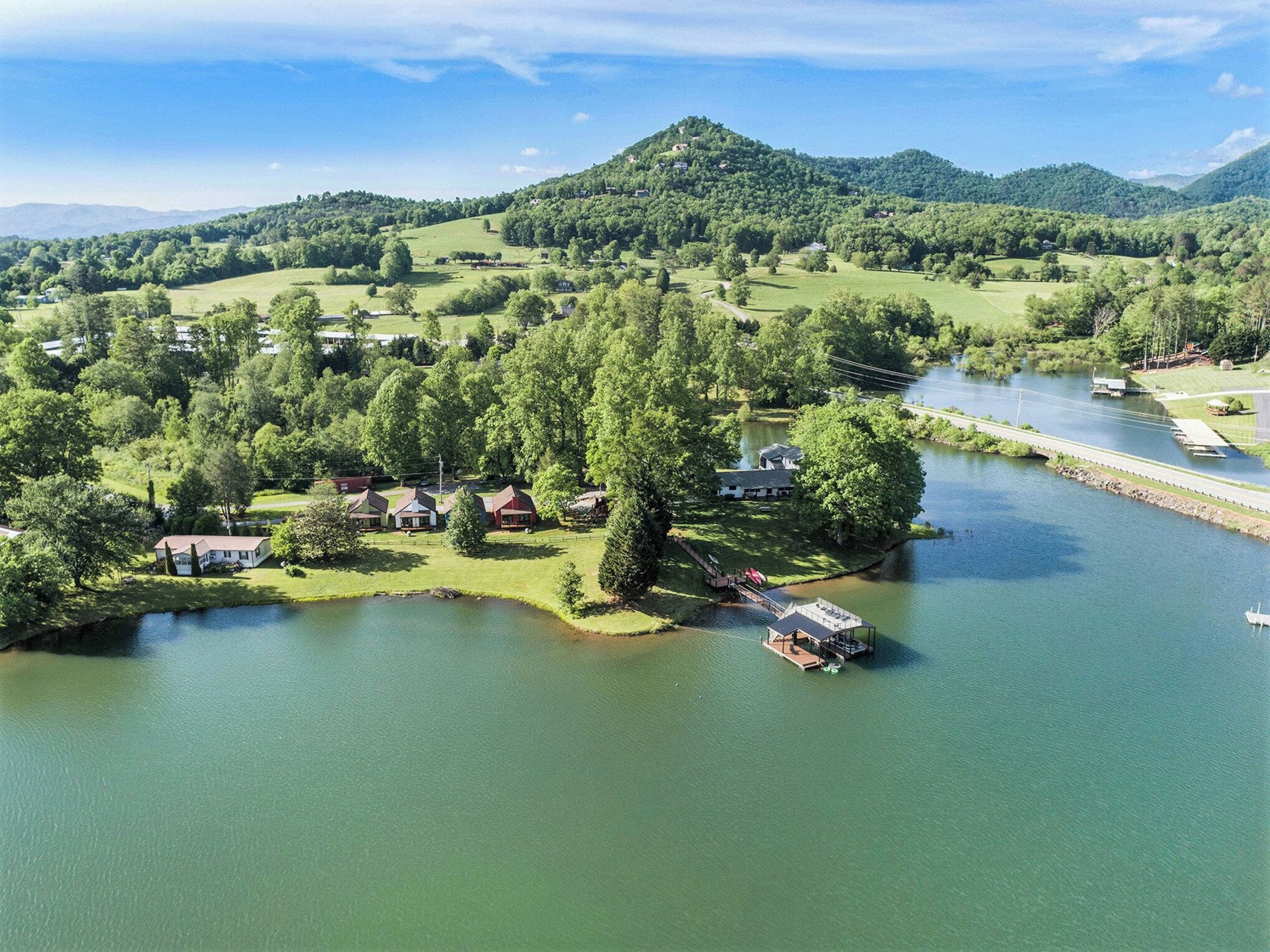 A lakeside property with multiple cabins, a dock, and a bridge connecting to the main land.