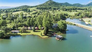 A lakeside property with multiple cabins, a dock, and a bridge connecting to the main land.
