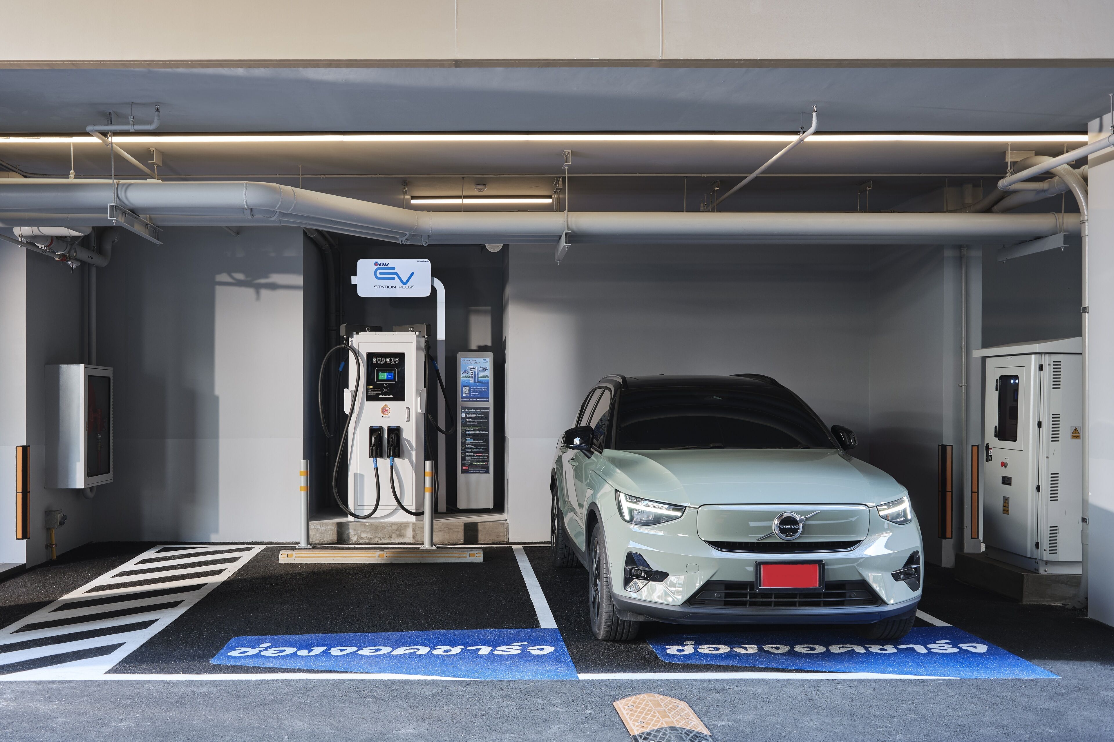 A charging station with a car parked inside a garage.